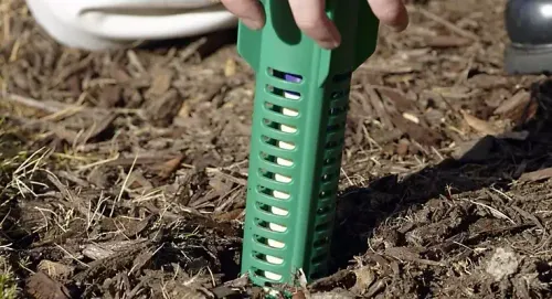 Sentricon termite bait station being installed in the ground near an Alexandria Virginia home